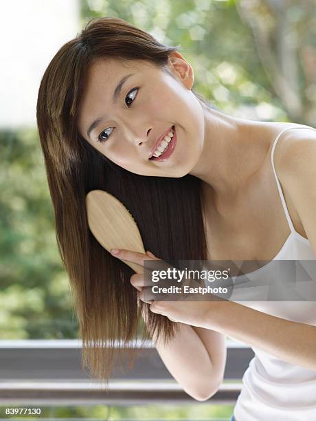 woman brushing hair. - brushing hair stock pictures, royalty-free photos & images