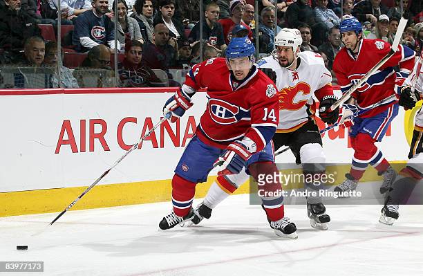 Tomas Plekanec of the Montreal Canadiens stickhandles the puck against Adrian Aucoin of the Calgary Flames at the Bell Centre on December 9, 2008 in...