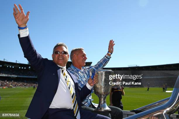 Past Eagles players Phil Narkle and Dwayne Lamb drive a lap of honour with a premiership cup during the round 23 AFL match between the West Coast...