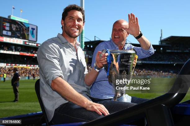 Past Eagles players Darren Glass and Dean Kemp drive a lap of honour with a premiership cup during the round 23 AFL match between the West Coast...