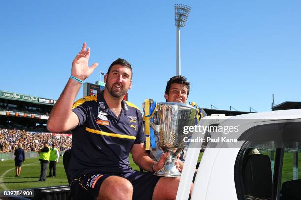 Past Eagles players Dean Cox and Andrew Embley drive a lap of honour with a premiership cup during the round 23 AFL match between the West Coast...