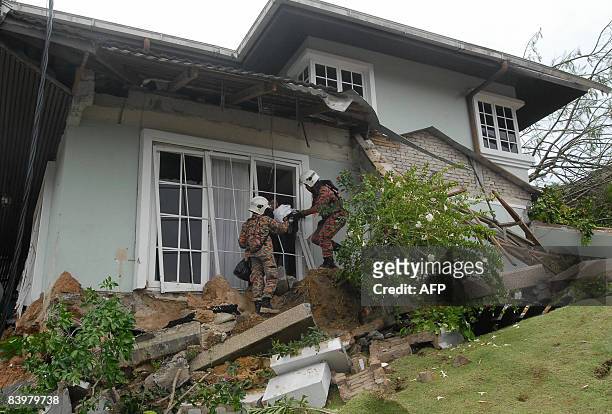 Rescue workers help survivors of a landslide in a residential area in Kuala Lumpur on December 7, 2008. Malaysia's prime minister Abdullah Ahmad...