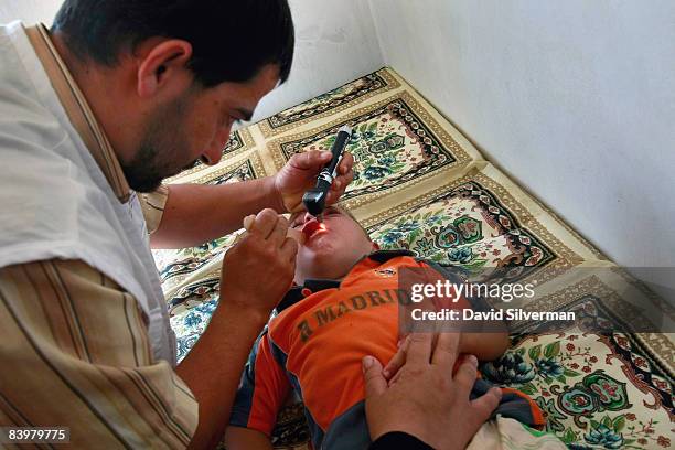 Palestinian physician Dr Muthanna Jabbarin examines a young boy at a mobile clinic provided by CARE International and funded by the European...