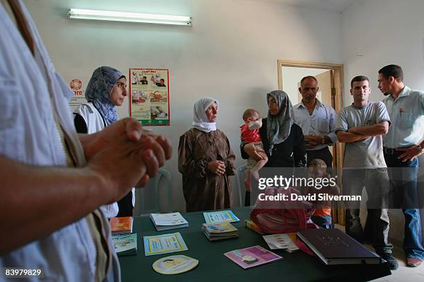 Palestinians wait for their turn to see the doctor at a mobile clinic provided by CARE International and funded by the European Commission's...