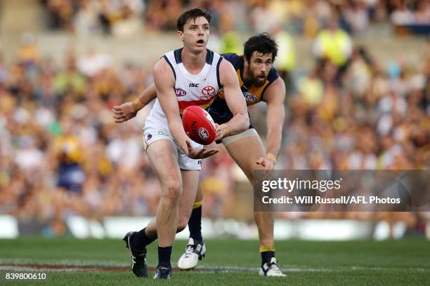 Jake Lever of the Crows handpasses the ball during the round 23 AFL match between the West Coast Eagles and the Adelaide Crows at Domain Stadium on...