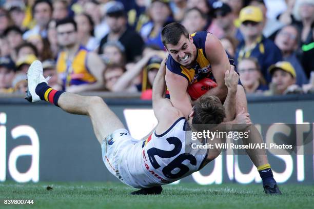 Jamie Cripps of the Eagles is tackled by Richard Douglas of the Crows during the round 23 AFL match between the West Coast Eagles and the Adelaide...