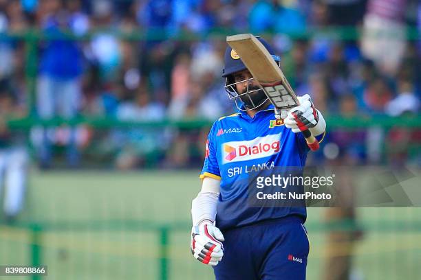 Sri Lankan cricketer Lahiru Thirimanne raises his bat after scoring 50 runs during the 3rd One Day International cricket match between Sri Lanka and...