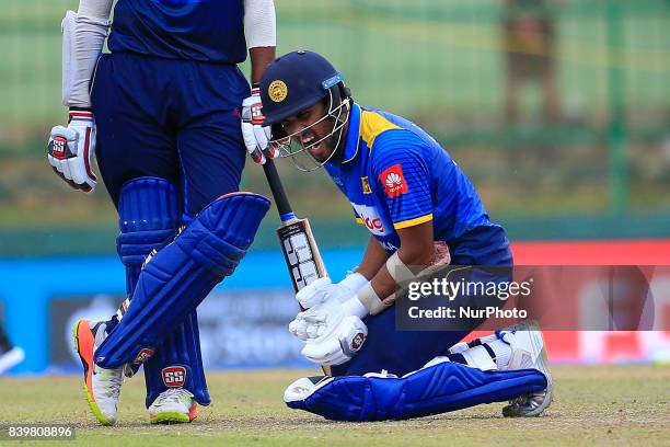 Sri Lankan cricketer Dinesh Chandimal reacts after the ball hit on his wrist during the 3rd One Day International cricket match between Sri Lanka and...