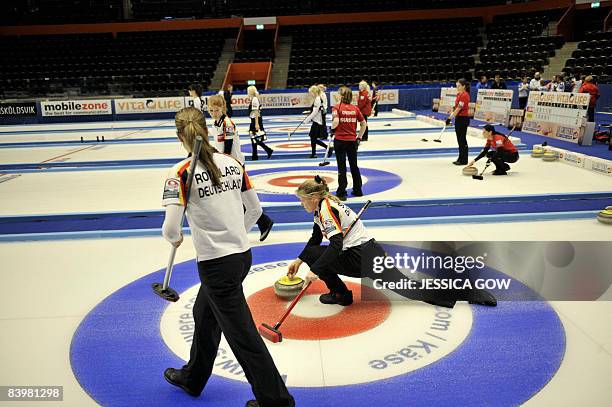 Germany's Andrea Schopp, , delivers the curling stone with teammate Melanie Robellard in the foreground, during the women's European Curling...