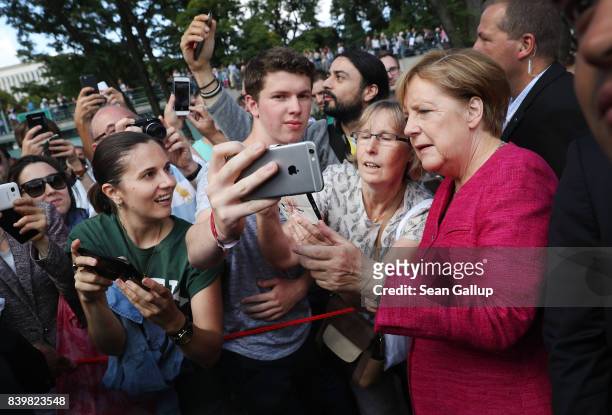 German Chancellor Angela Merkel pauses for a selfie among visitors during the annual open-house day at the Chancellery on August 27, 2017 in Berlin,...