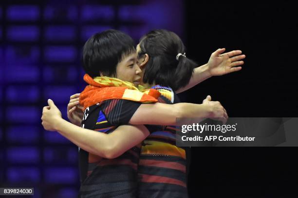 China's Jia Yifan and Chen Qingchen react after their victory over Japan's Yuki Fukushima and Sayaka Hirota in their women's doubles final match...