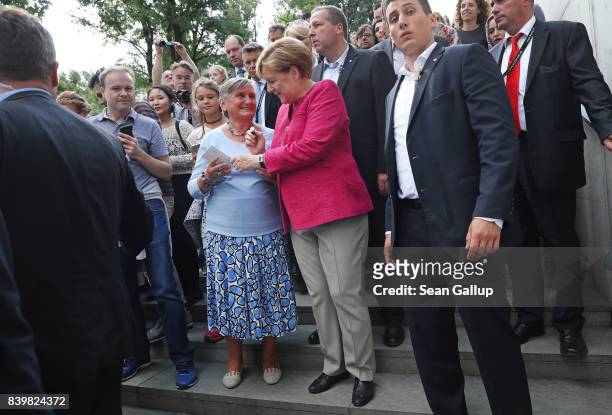 German Chancellor Angela Merkel signs an autograph while greeting visitors during the annual open-house day at the Chancellery on August 27, 2017 in...