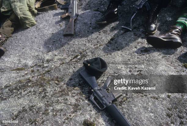 Trainee members of the Provisional Irish Republican Army take a break on a hilltop to go through guerilla warfare tactics during a training session...