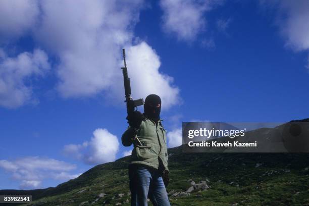 Armed with with an M16 automatic assault rifle, a trainee member of the Provisional Irish Republican Army stands guard on a hilltop, while his...