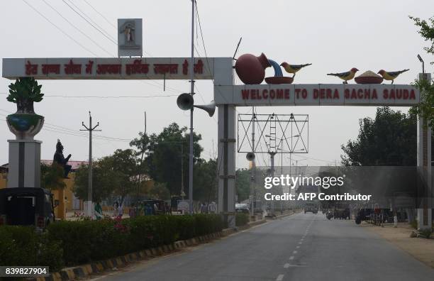 Welcome sing of the 'Dera Sacha Sauda' ashram of controversial Indian guru Ram Rahim Singh is seen along an empty road in Sirsa on August 27, 2017....