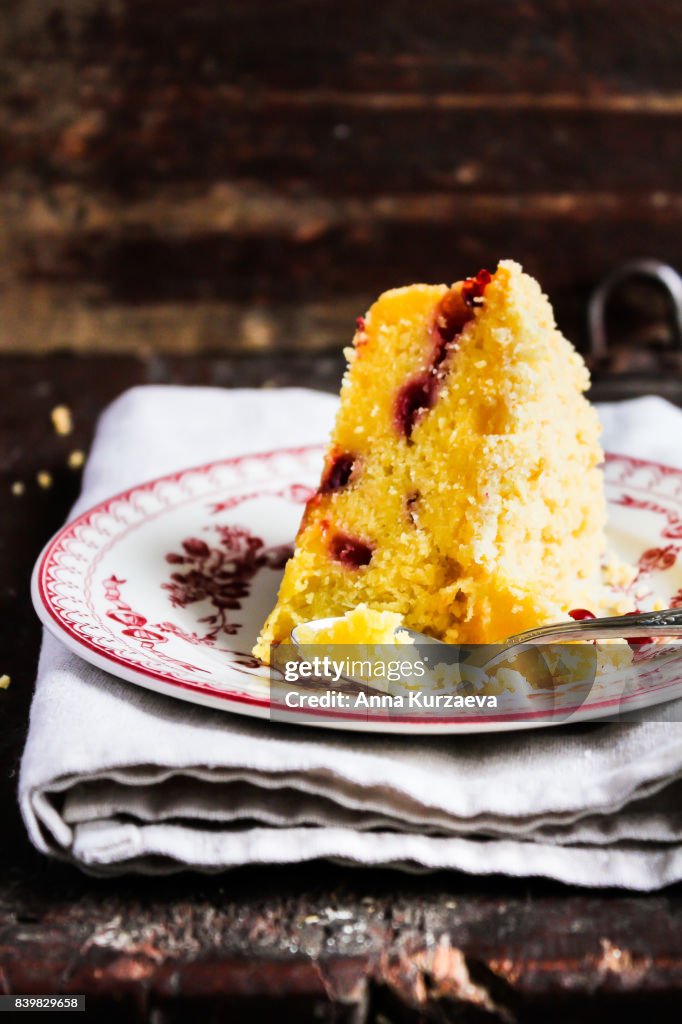 Piece of pound crumb lemon cake with fresh berry on a dessert plate, selective focus