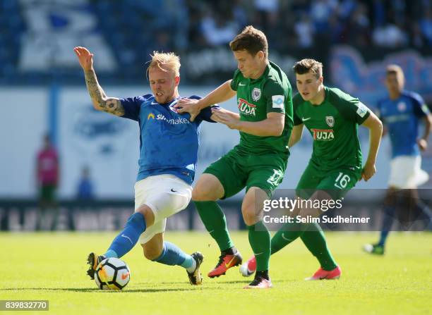 Marcel Hilsner of Hansa Rostock fights for the ball with Tobias Ruehle and Tobias Warschewski of Preussen Muenster during the 3. Liga match between...