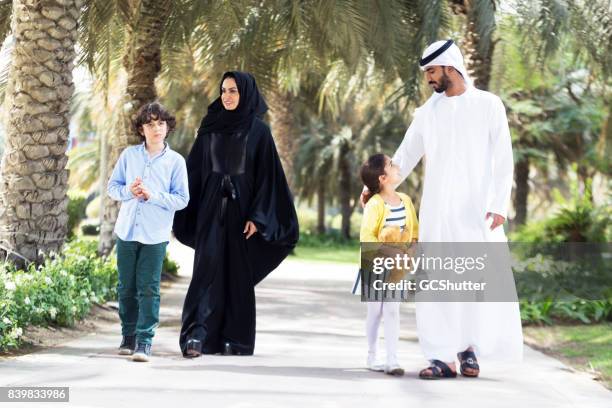 arab family taking a stroll in a public park - abu dhabi people stock pictures, royalty-free photos & images