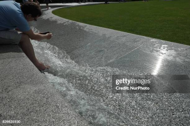 People cool off in the Diana memorial fountain in London's Hyde Park, UK, on 26 August 2017.