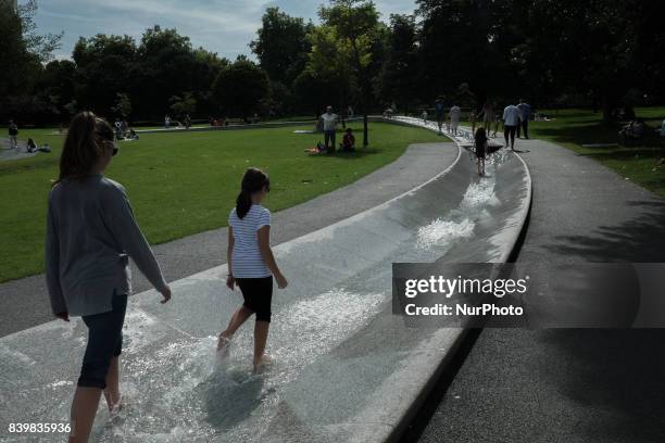 People cool off in the Diana memorial fountain in London's Hyde Park, UK, on 26 August 2017.