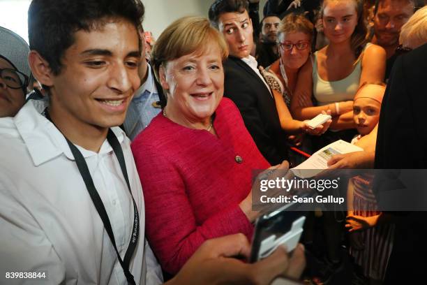 German Chancellor Angela Merkel pauses for a selfie among visitors during the annual open-house day at the Chancellery on August 27, 2017 in Berlin,...