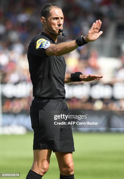 French main referee Mikael Lesage gestures during the French Ligue 1 football match between Guingamp and Strasbourg on August 27, 2017 at the...