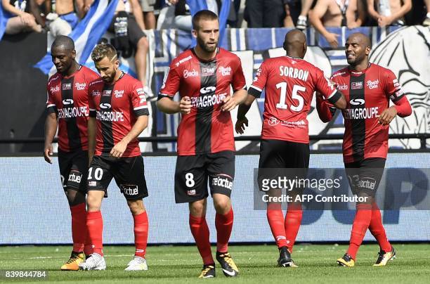Guingamp's French forward Jimmy Briand is congratulated by his teammates afterhe scored during the French Ligue 1 football match between Guingamp and...