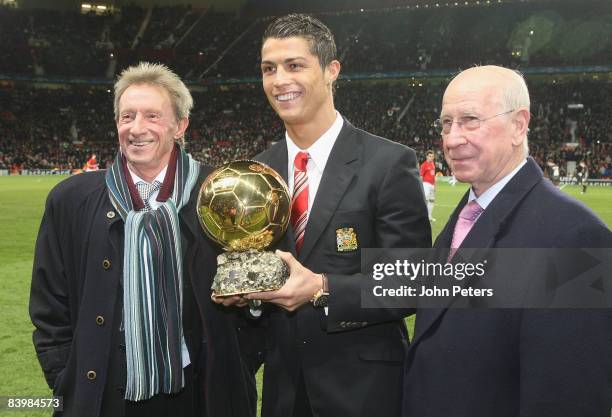 Cristiano Ronaldo of Manchester United is presented with the Ballon D'Or by Denis Law and Sir Bobby Charlton ahead of the UEFA Champions League Group...