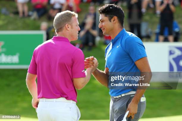 Julian Suri of the United States is congratulated by David Horsey of England on his victory on the 18th green during the final round of Made in...