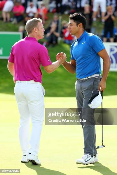 Julian Suri of the United States is congratulated by David Horsey of England on his victory on the 18th green during the final round of Made in...