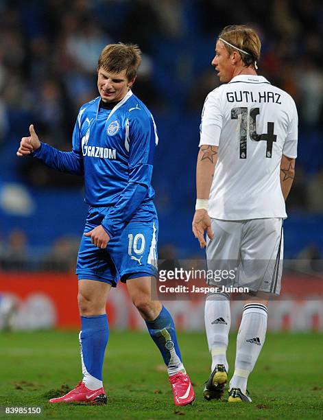 Andrei Arshavin of Zenit St. Petersburg gestures to a teammate while flanked by Jose Maria Gutierrez of Real Madrid during the UEFA Champions League...