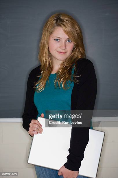 teen girl holding laptop in classroom, portrait - blackboard qc stock pictures, royalty-free photos & images