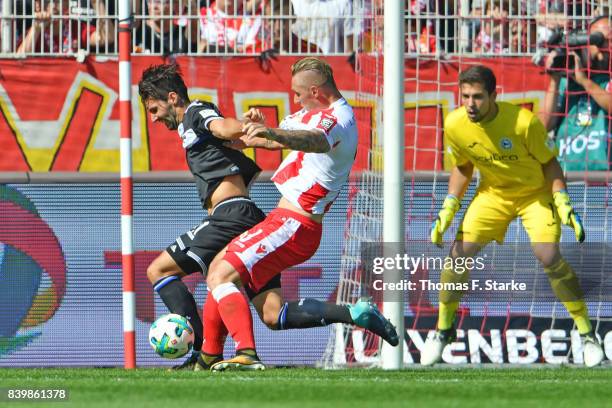 Sebastian Polter of Berlin tackles Stephan Salger of Bielefeld right before the first goal of Berlin during the Second Bundesliga match between 1. FC...