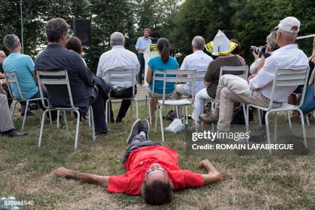 Man lies on the ground as French MP of Les Landes and spokesman of the parlamentiary group "Nouvelle Gauche" Boris Vallaud delivers a speech during...