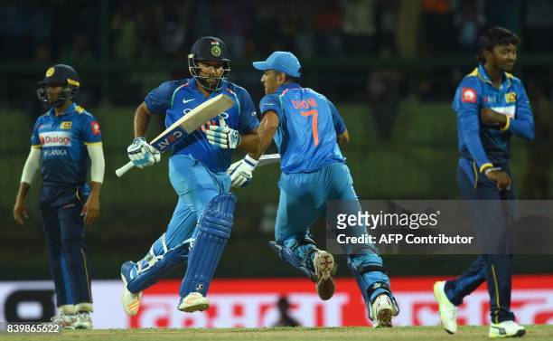 Indian cricketer Rohit Sharma and Mahendra Singh Dhoni run between the wickets during the third one day international cricket match between Sri Lanka...