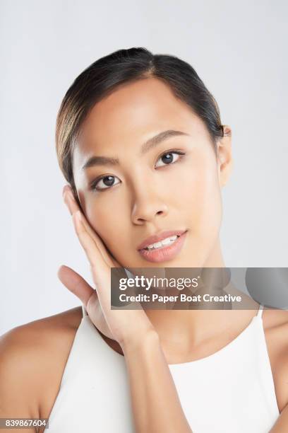 asian milennial about to share her beauty and body care secrets - frau braune haut brünette stock-fotos und bilder