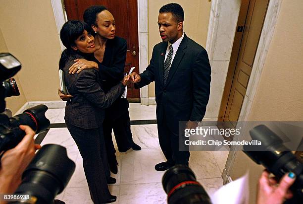 Rep. Jesse Jackson Jr. , talks to the news media as his wife Sandi Jackson and his sister Jacqueline Lavinia Jackson embrace after a news conference...
