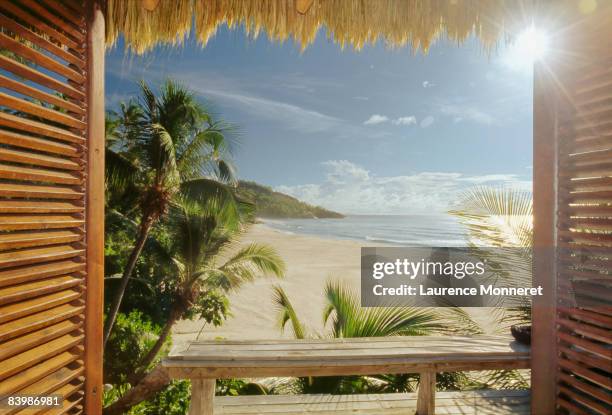 opened wooden window on wild tropical beach - seychelles stockfoto's en -beelden