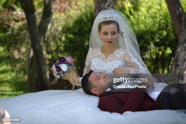 Bride and a groom pose for a picture as people enjoy 10-day holiday for Muslims' traditional festival Eid al-Adha at the Goksu Park in Ankara, Turkey...