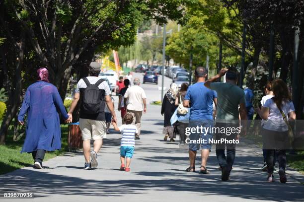 Parents and their children walk on a path as people enjoy 10-day holiday for Muslims' traditional festival Eid al-Adha at the Goksu Park in Ankara,...