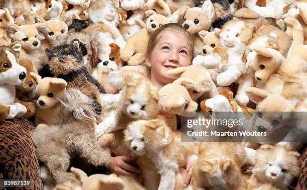 close up of a girl surrounded by stuffed toys - excess stock-fotos und bilder