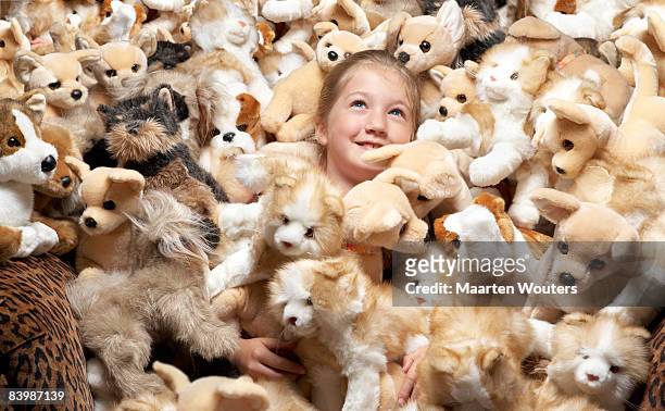 close up of a girl surrounded by stuffed toys - excess photos et images de collection
