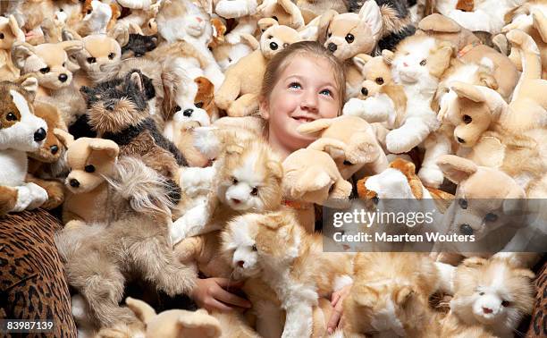 close up of a girl surrounded by stuffed toys - peluche foto e immagini stock