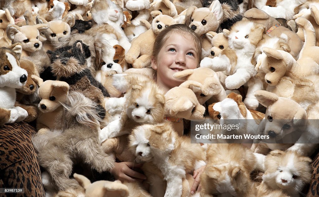 Close up of a girl surrounded by stuffed toys
