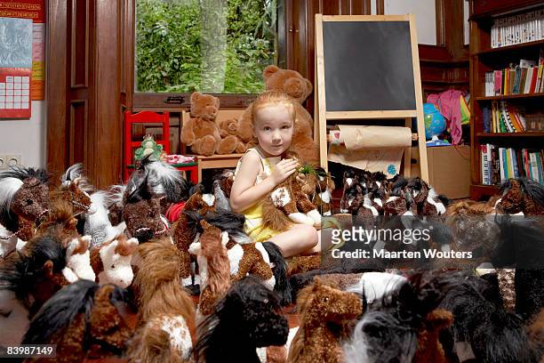 portrait of a girl among her toy horses - too much stock pictures, royalty-free photos & images
