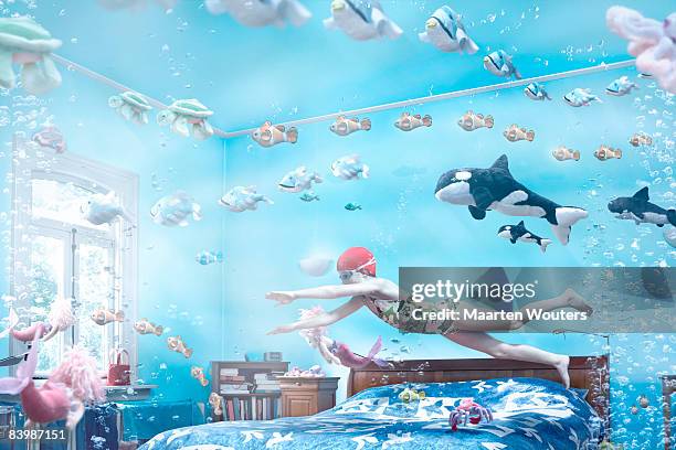 girl swimming in her bedroom - kids room stock-fotos und bilder