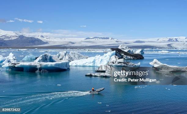 rigid inflatable boat amongst icebergs in glacier lagoon at jokulsarlon, iceland - breidamerkurjokull glacier stock pictures, royalty-free photos & images