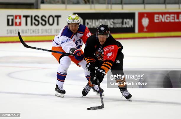 Mark Voakes of Wolfsburg and Juhani Jasu of Tampere battle for the puck during the Champions Hockey League match between Grizzlys Wolfsburg and...