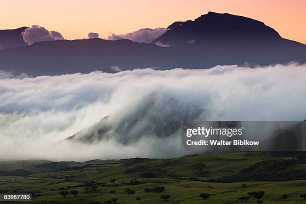 clouds rolling over mountain landscape - obscurity stock pictures, royalty-free photos & images