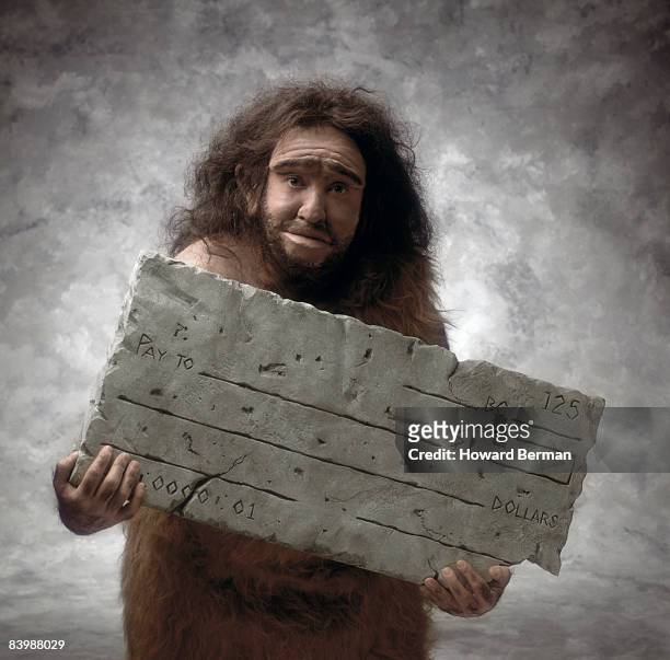 caveman with check - neanderthal stock pictures, royalty-free photos & images